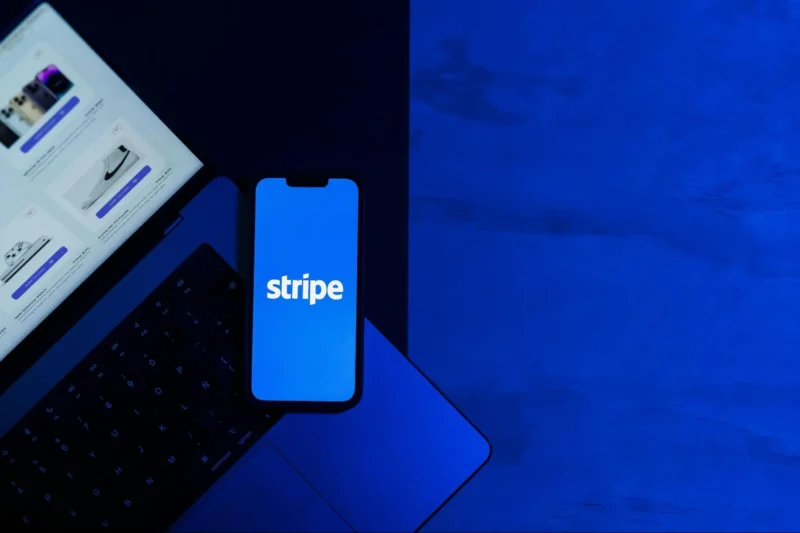 Stripeのロゴが表示されたスマートフォンとノートパソコン。次世代の決済やエージェンティックコマースの調査背景を象徴するイメージ画像。