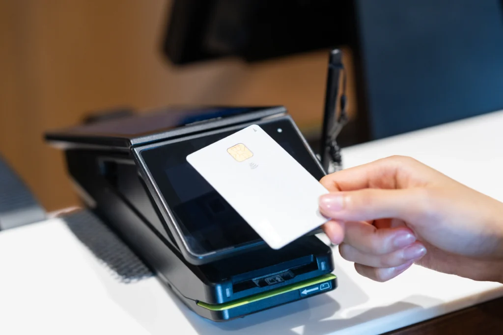 店舗の端末でクレジットカードのタッチ決済をする手（ネット決済代行サービス市場規模予測記事アイキャッチ）